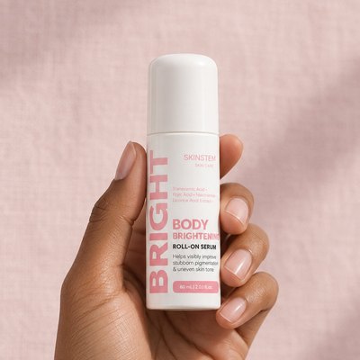 A hand holding the Skinstem Body Brightening Roll-On Serum